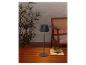 Lampe de table portable grise sur une table en bois extérieure.