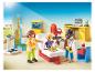 Playmobil-poppetjes in een dokterspraktijk met een weegschaal en een giraffe-lengtemeter.