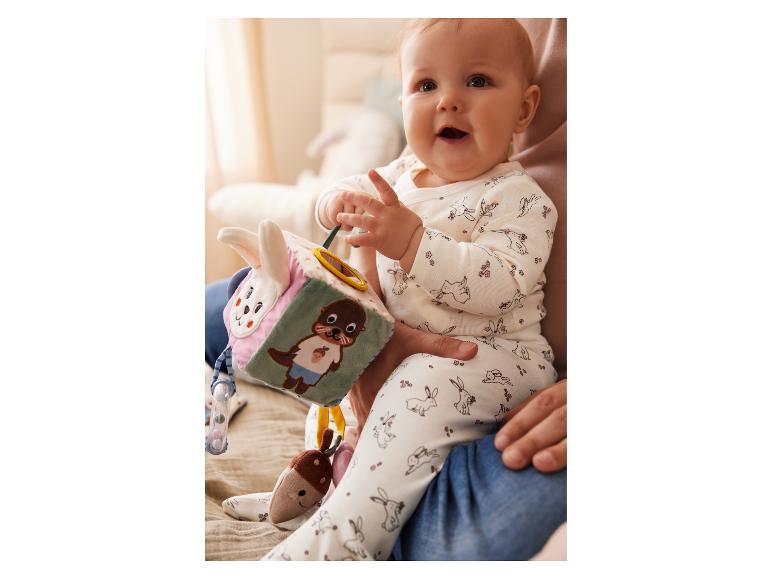 Een baby speelt met een Little Dutch activiteitendoos.