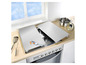 Deux protections de plaque de cuisson grises sur une cuisinière à gaz.