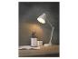 Een witte bureaulamp, een notitieboek en pennen op een houten bureau.