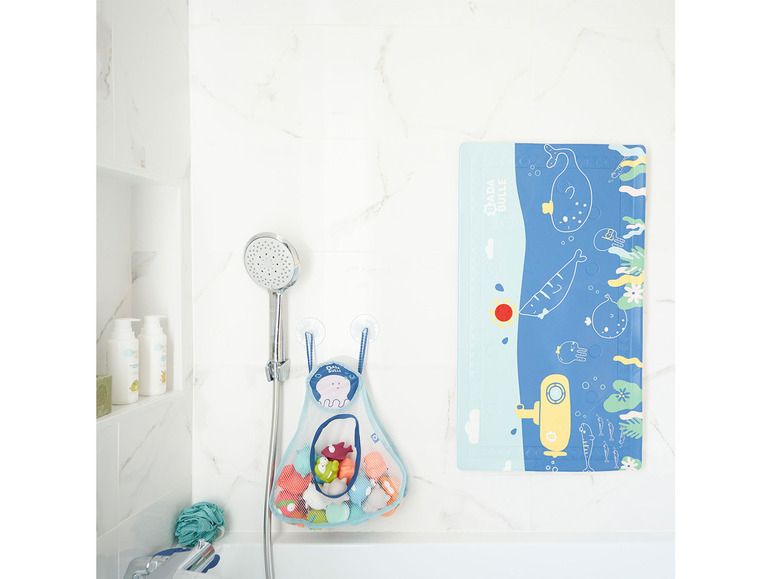 Tapis de bain à thème marin et un filet pour les jouets de bain.