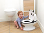 Een baby die naast een panda-potje zit in een badkamer.
