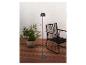 Ambiance extérieure avec un lampadaire noir, une chaise en corde noire et une plante en pot sur une terrasse en bois.