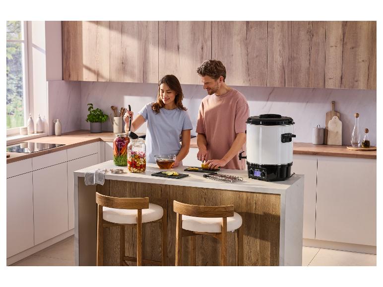 SILVERCREST® SEAD 1800 B2 elektrische inmaakketel op een kookeiland met een stel dat eten bereidt