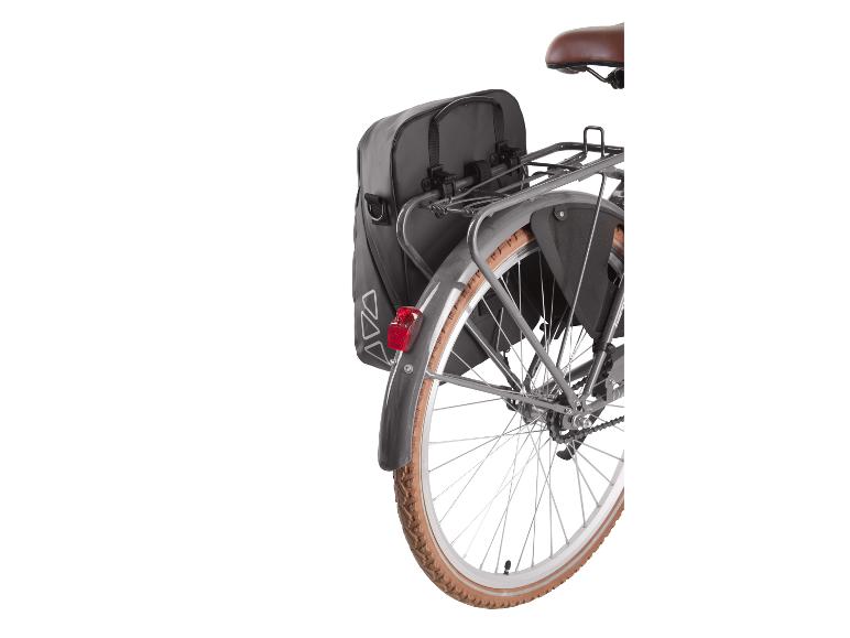 Zwarte achterfietstassen op een fietsenrek met een bruine band.