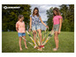 Drie meisjes spelen een spel met lange houten stokjes in de tuin.