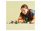 Fille jouant avec un ensemble de construction de maison et des figurines de personnages.