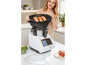 Een vrouw plaatst zalm in een stoommandje van een witte Thermomix-kookmachine.