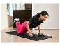 Vrouw doet push-ups met push-up bars op een trainingsmat van Decathlon.