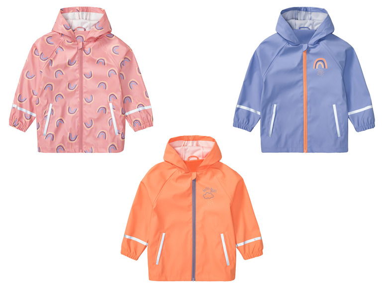 Drie regenjassen met regenboogmotief.