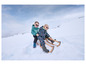 Twee kinderen op een slee in de sneeuw.
