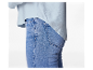 Vrouw in een lichtblauw overhemd en lichtblauwe jeans.