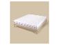 Matelas blanc avec surmatelas sur un cadre de lit en bois clair sur fond beige.