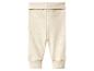 Pantalon bébé côtelé beige clair avec une large ceinture repliable et des chevilles resserrées.