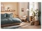 Chambre moderne avec lit et literie bleu-gris, étagères et plantes.