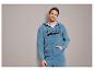 Man in een blauwe hoodie met 'Originals' print.