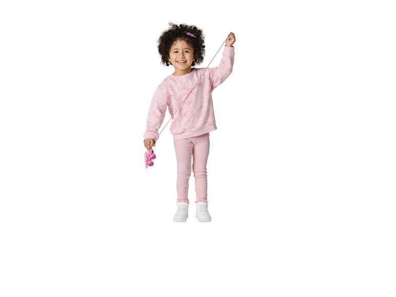 Lachend meisje in roze sweatshirt en legging met een roze speelgoedauto.