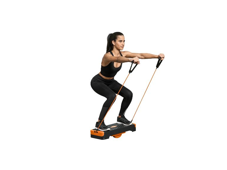 Femme faisant des squats avec des bandes de résistance sur une plateforme d'exercice.