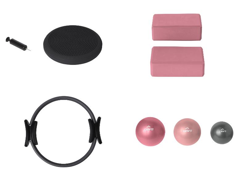 Un anneau de fitness noir, deux blocs de yoga roses et trois ballons de fitness Crivit.