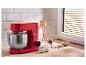 Robot pâtissier rouge SilverCrest avec bol en acier inoxydable et ingrédients de pâtisserie sur un comptoir en bois.