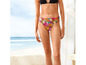 Een vrouw draagt een bikini met een tropische print op het strand.