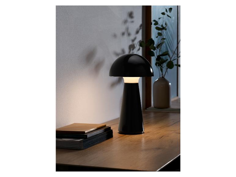 Een zwarte tafellamp met een paddenstoelvormige kap op een houten tafel.