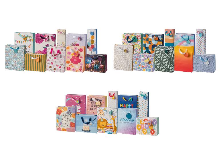 Assortiment de sacs cadeaux colorés avec divers motifs et messages 'Happy Birthday'.