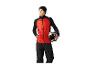 Homme en gilet matelassé rouge et pantalon noir, tenant un casque de ski.