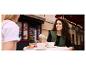 Twee vrouwen genieten van koffie en ontbijt buiten.