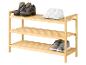 Étagère à chaussures en bois avec bottes de randonnée, baskets blanches et chaussures pour enfants grises.