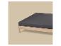 Licht houten bed met donkergrijs matras op een beige achtergrond.