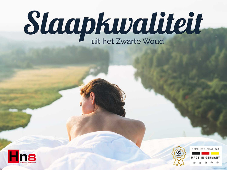 Een vrouw die in bed ligt van Hna met uitzicht op een meer, reclame voor matrassen.
