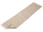 Een beige vloerkleed met franjes.