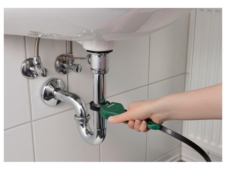 Main utilisant un outil de nettoyage de drain Parkside sur un tuyau d'évier.