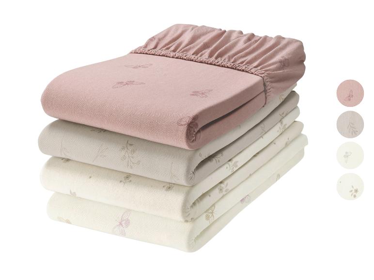Ensemble de draps-housses pour enfants avec motifs papillons et floraux en tons rose et beige.