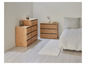 Twee houten dressoirs met lades, een vloerkleed en een bed.