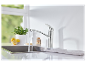 Grohe keukenkraan met stromend water in een roestvrijstalen gootsteen.