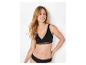 Femme en soutien-gorge d'allaitement et culotte noirs, souriante et regardant sur le côté.