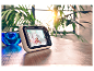 Een Motorola babyfoon toont een schattig baby'tje op een houten tafel.