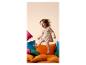 Petite fille heureuse sautant sur des coussins colorés.