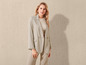 Een vrouw in een beige blazer en broek.