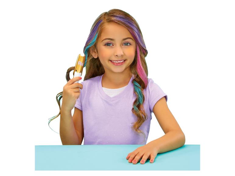 Fille avec des mèches colorées dans les cheveux tenant un appareil de coloration capillaire.