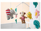 Un mobile pour bébé avec un singe, un éléphant, un lion et des fleurs.