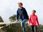 Deux femmes en vestes et vêtements de sport marchent dans la nature.
