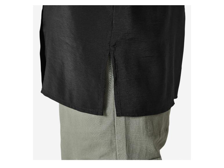 Een zwart T-shirt met een zijsplit gecombineerd met een groene broek.