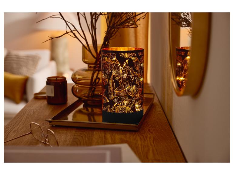 LIVARNO home led-lantaarn met bladpatroon op een houten tafel.