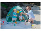 Twee kinderen spelen met zand speelgoed in een blauwe tent op het strand.