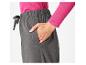 Pantalon gris avec un pull rose.