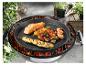 Poêle grill avec saumon, légumes, crevettes et brochette de poulet sur un barbecue.